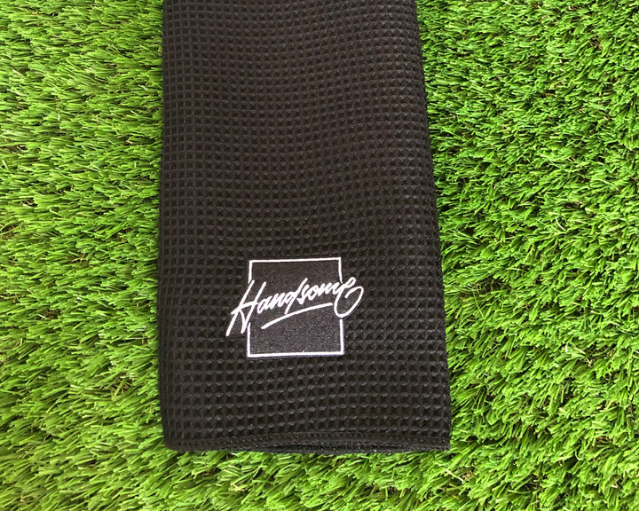 Black waffle pattern golf towel with Handsome Bogey's logo. 